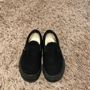 Kids all black slip on Vans.